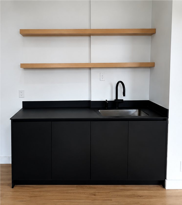 Dominion Building Unit 1400 kitchenette with black cabinetry and oak floating shelves